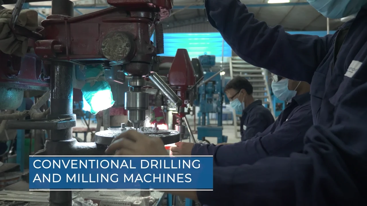 An operator working with machining equipment on a factory floor